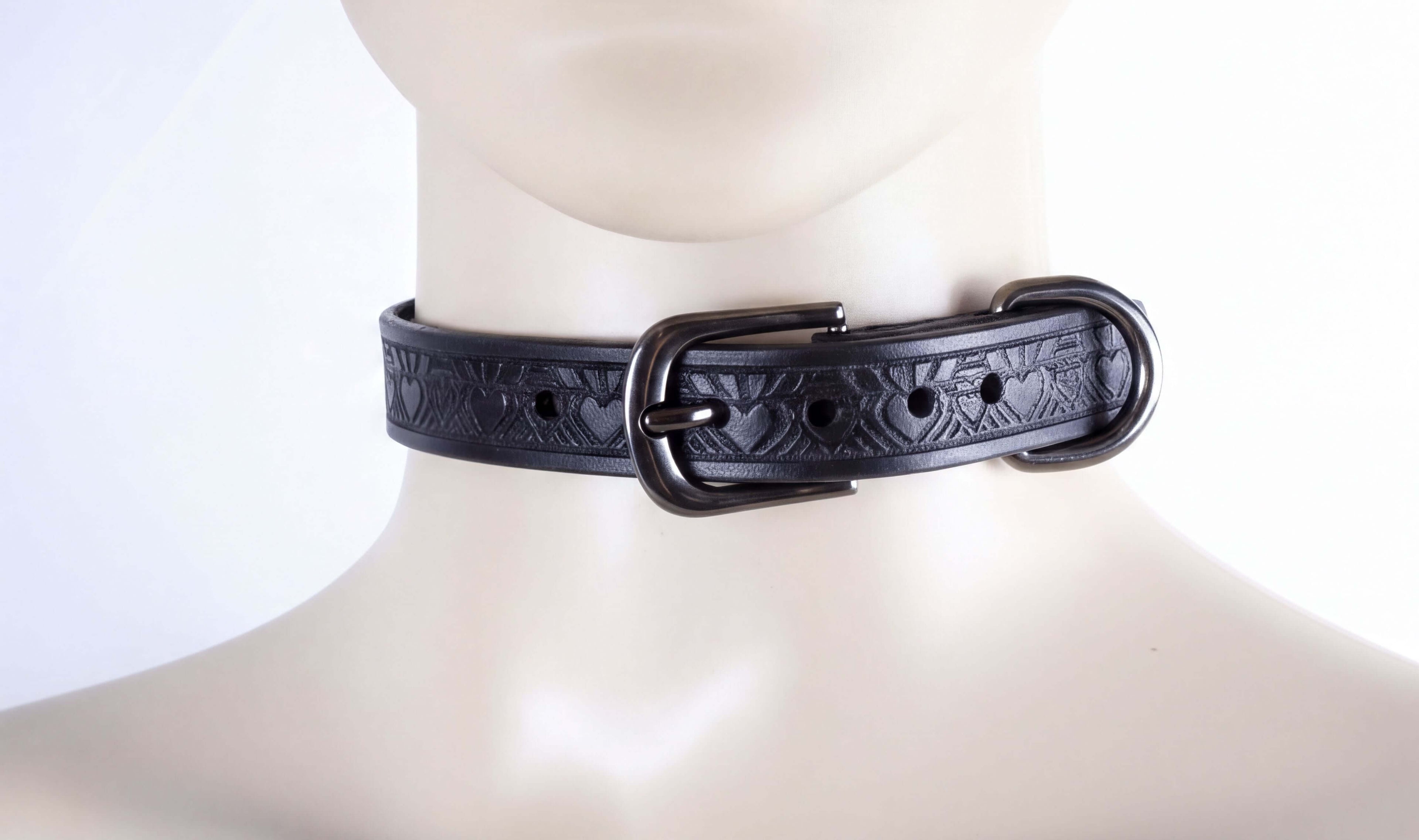 A close-up view of a black leather choker necklace with a decorative buckle.