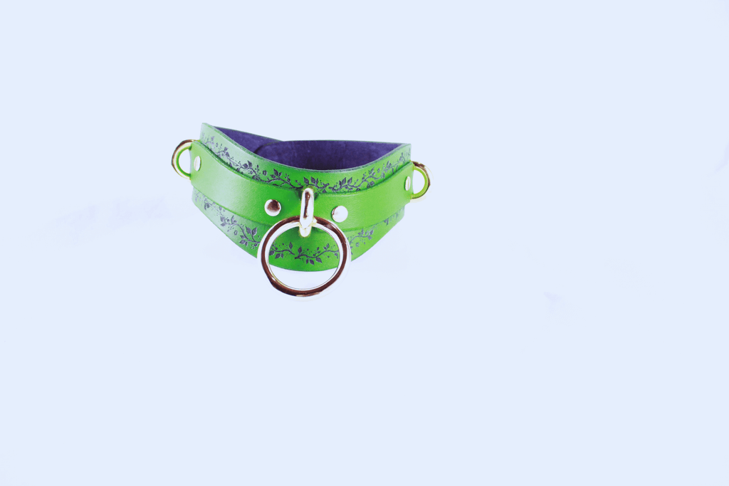 Green Vine Leather Submissive Collar with silver rings and black vine pattern on a fresh green background.