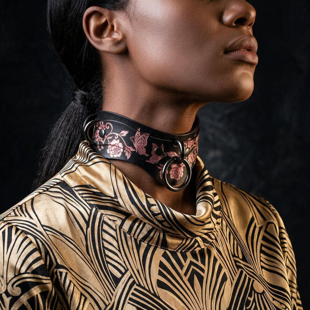 A close-up of a woman's neck and chest area, featuring a choker-style collar with a floral pattern and metal rings.
