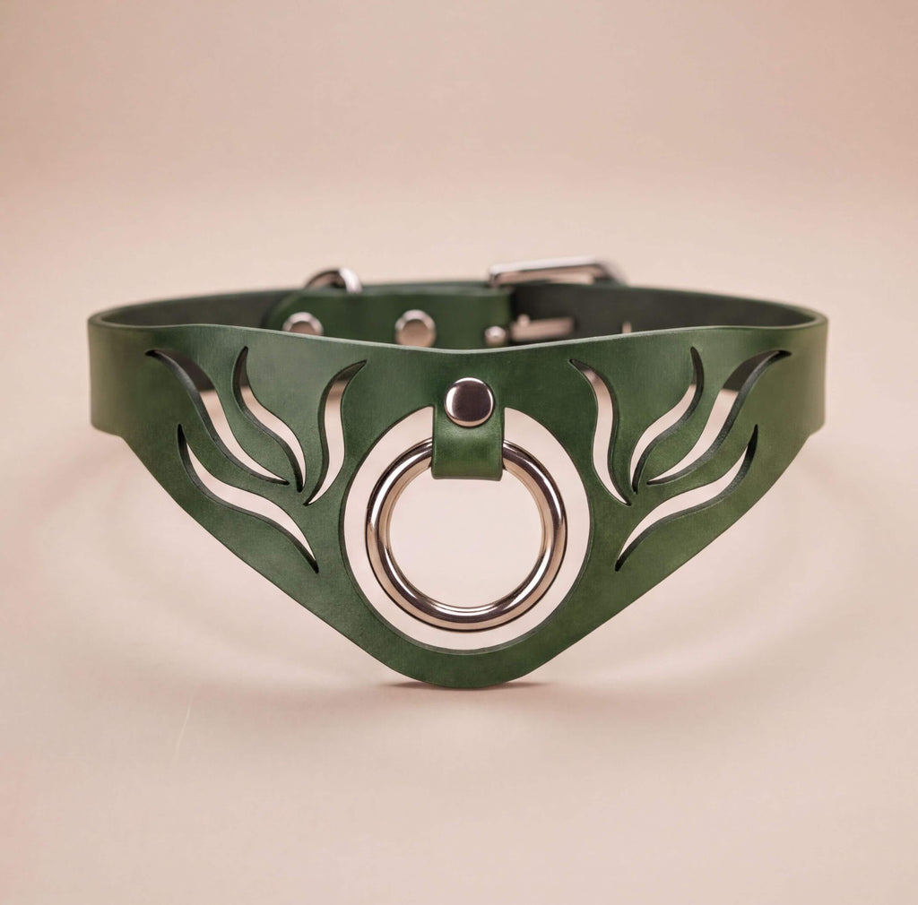 A green leather choker necklace with a silver ring and leaf-like cutout design.