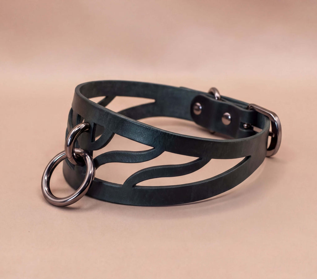 A black leather choker necklace with metal rings and a metal buckle.