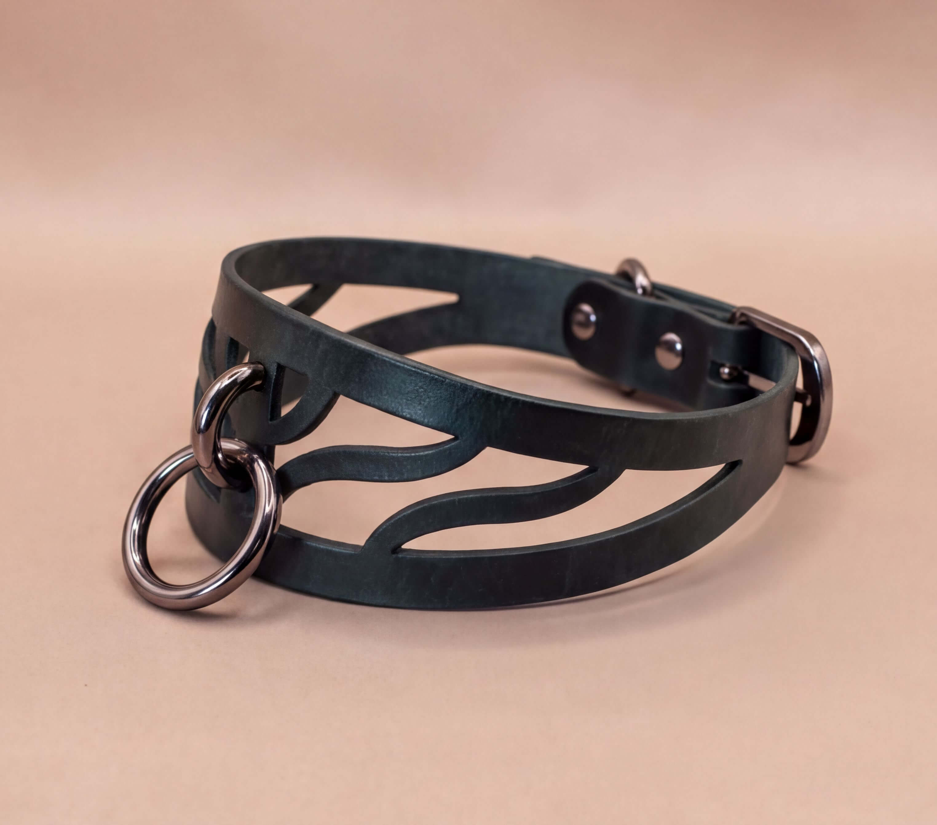 A black leather choker necklace with metal rings and a metal buckle.