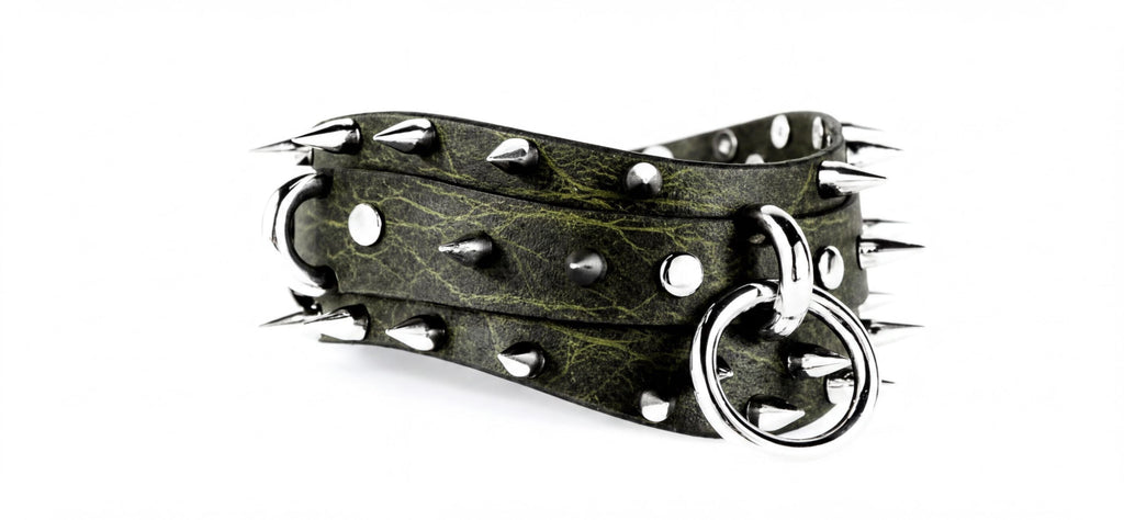 A close-up image of a green leather belt with silver studs and a ring-like attachment.