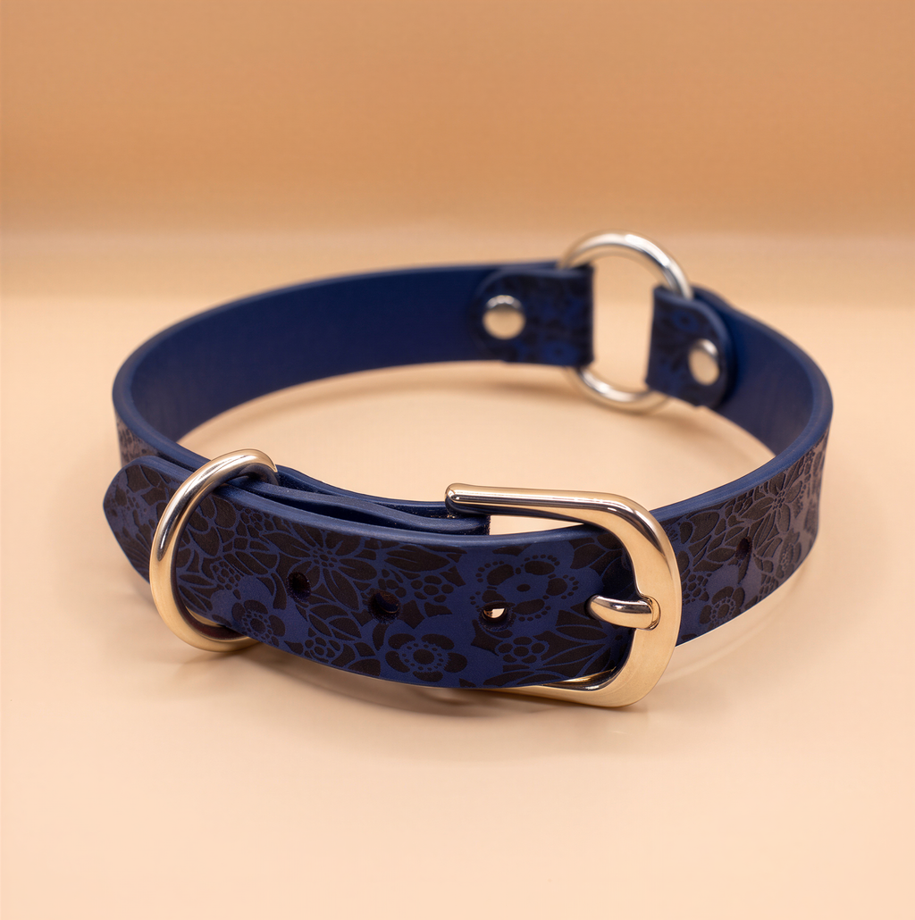 A blue leather collar with a floral pattern and metal buckle.