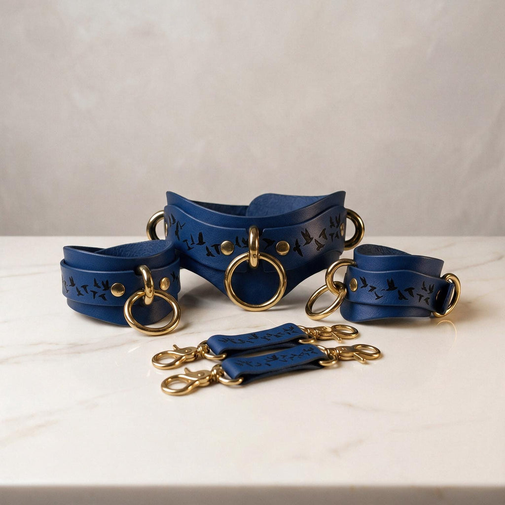 A set of blue leather straps with gold rings and buckles, arranged on a white marble surface.