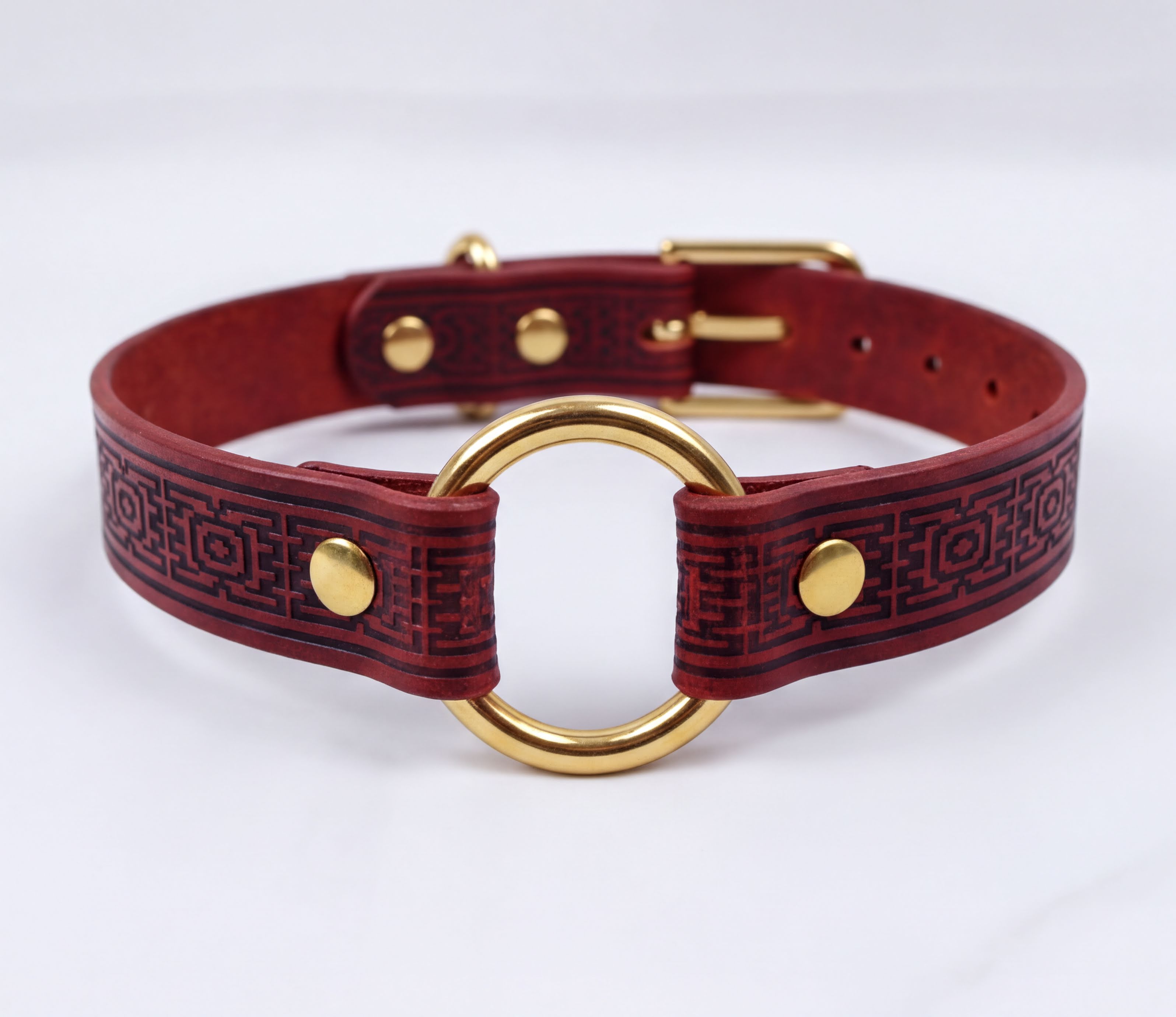 A burgundy leather choker collar with a gold-colored metal ring and buckle.