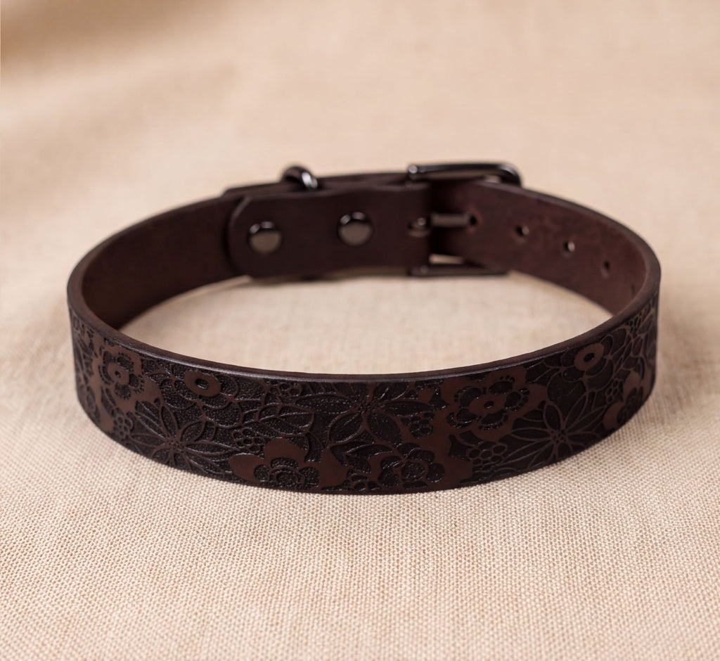 A brown leather dog collar with a floral pattern on the surface.