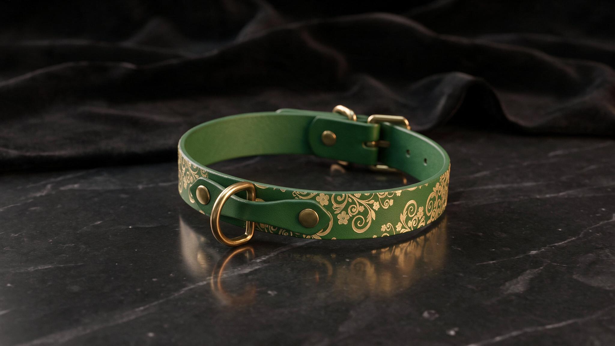 A green leather collar with a gold floral pattern sits on a black marble surface.