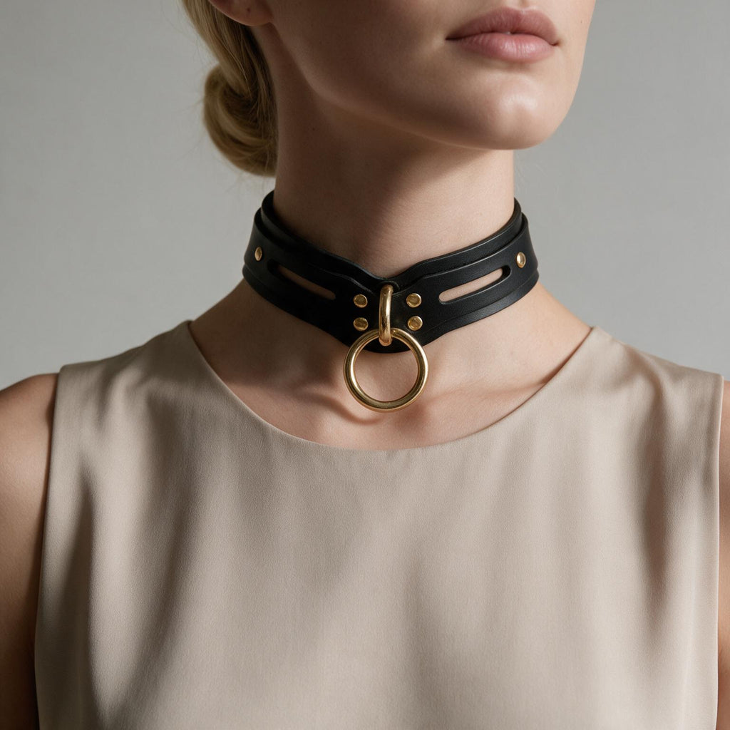 A woman wearing a black choker necklace with a gold ring on it.
