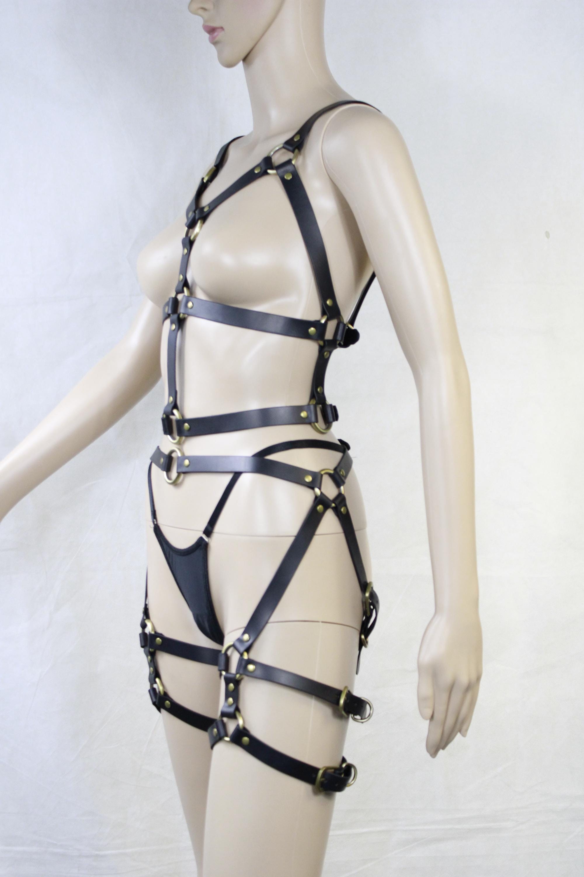 A mannequin wearing a leather strap ensemble, including a strapless top and straps, is shown in the image.