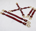 a collection of red leather straps with gold-colored heart-shaped buckles, arranged in various orientations on a white background.
