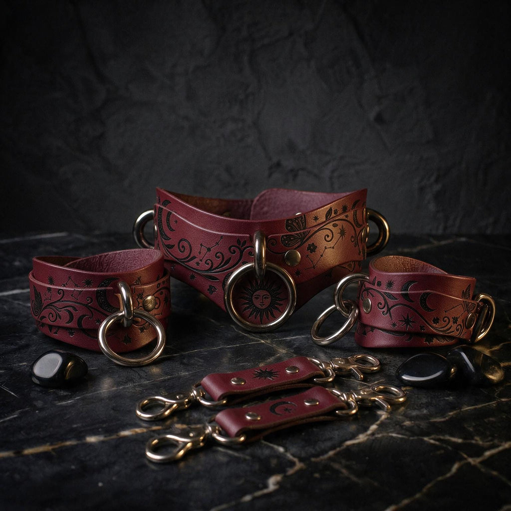 a collection of burgundy leather choker necklaces and straps, each adorned with intricate designs and metal rings, displayed on a dark marble surface.