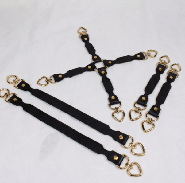 A collection of black leather straps with gold heart-shaped buckles, arranged in various orientations on a white background.