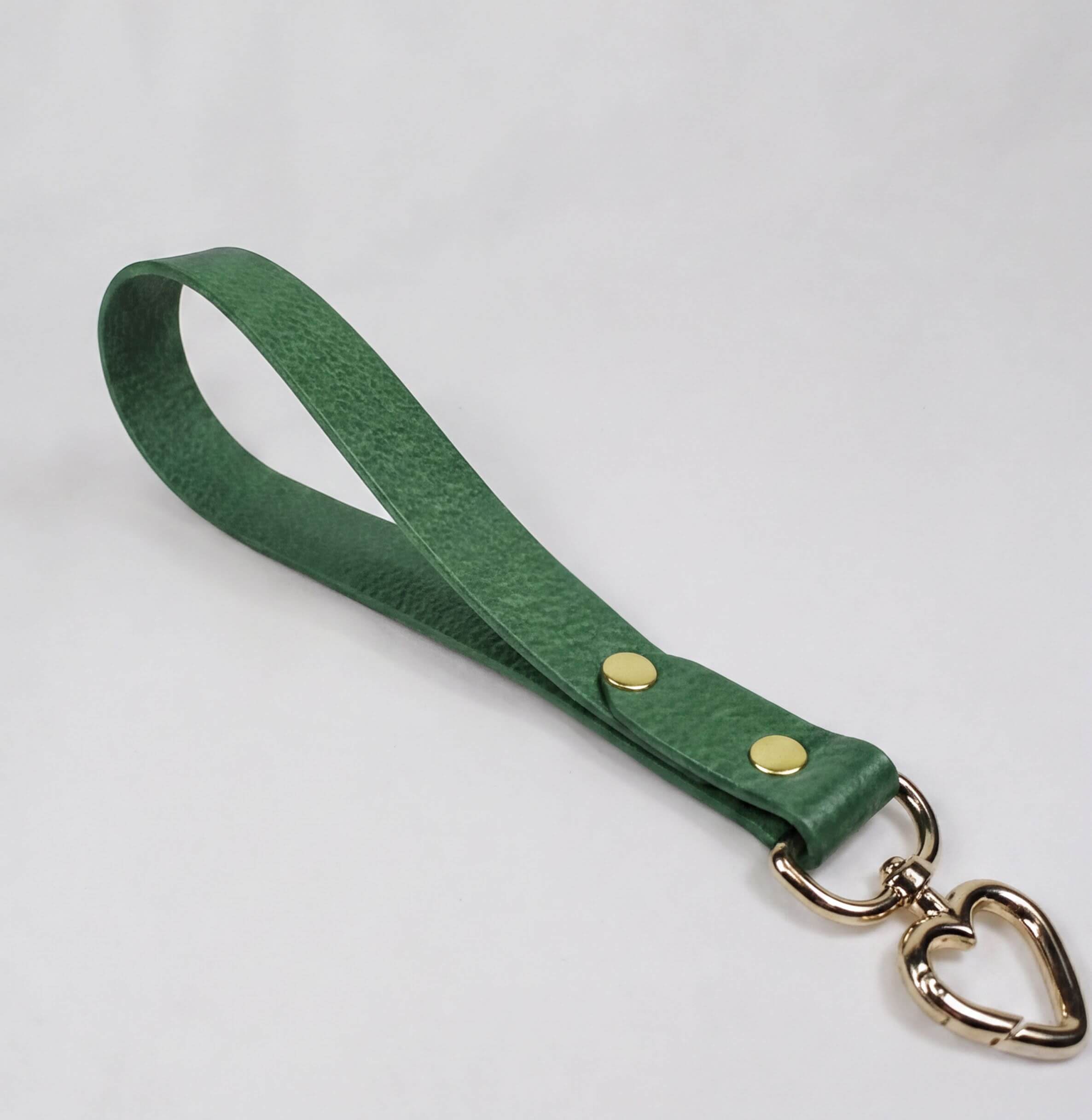 A green leather strap with a heart-shaped metal clasp attached to it.
