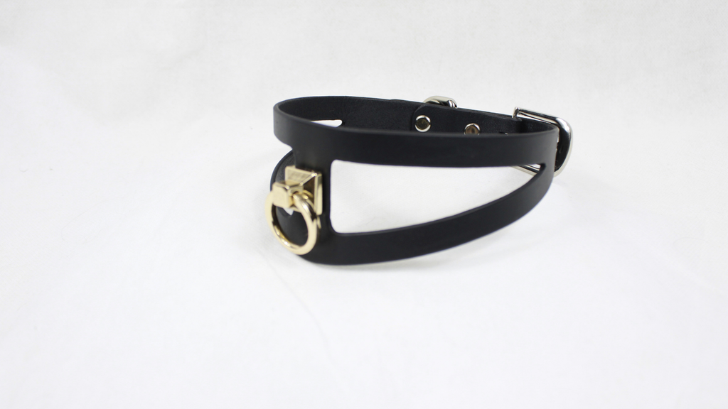 A black leather choker necklace with a gold-colored metal clasp.