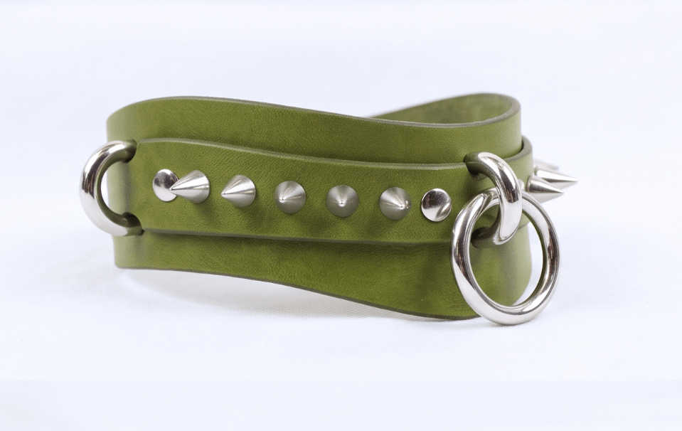 A green leather choker necklace with metal spikes and a metal ring.