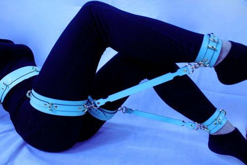 Blue leather thigh harness and cuffs for bondage play, ideal for submissive positioning and BDSM gear.
