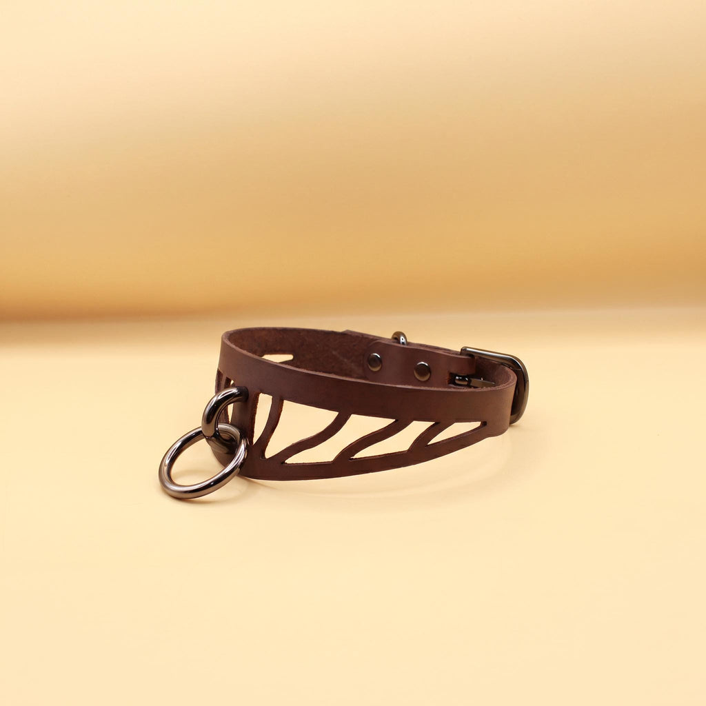 A brown leather choker necklace with a metal clasp and a zebra print design.