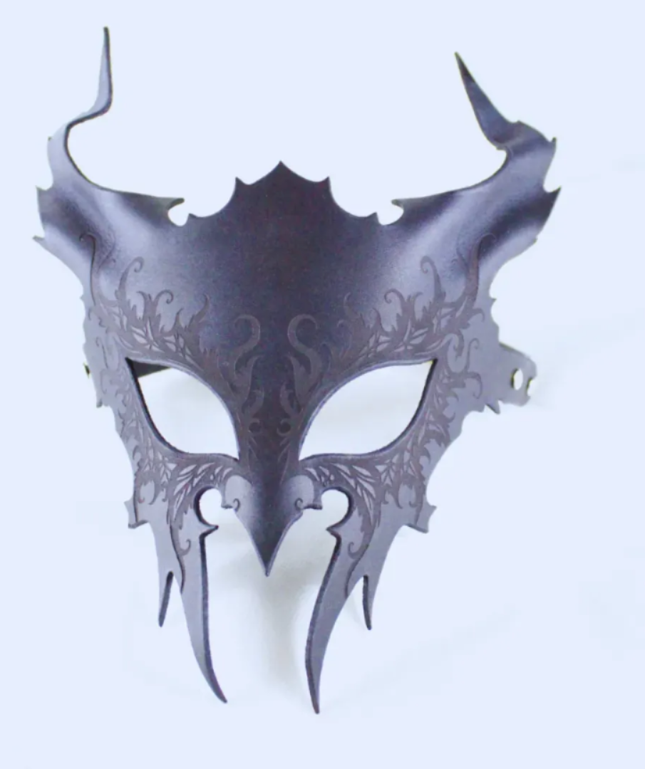 A dark, ornate mask with intricate designs and sharp, pointed features.