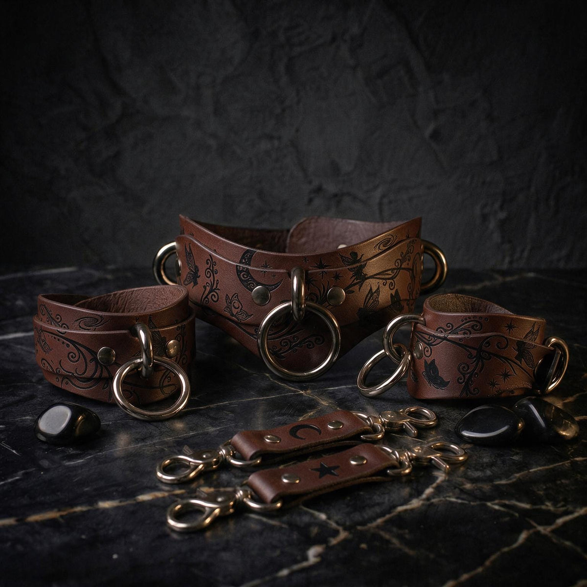 a collection of leather straps and buckles, including a corset-style belt and other accessories, arranged on a dark surface.