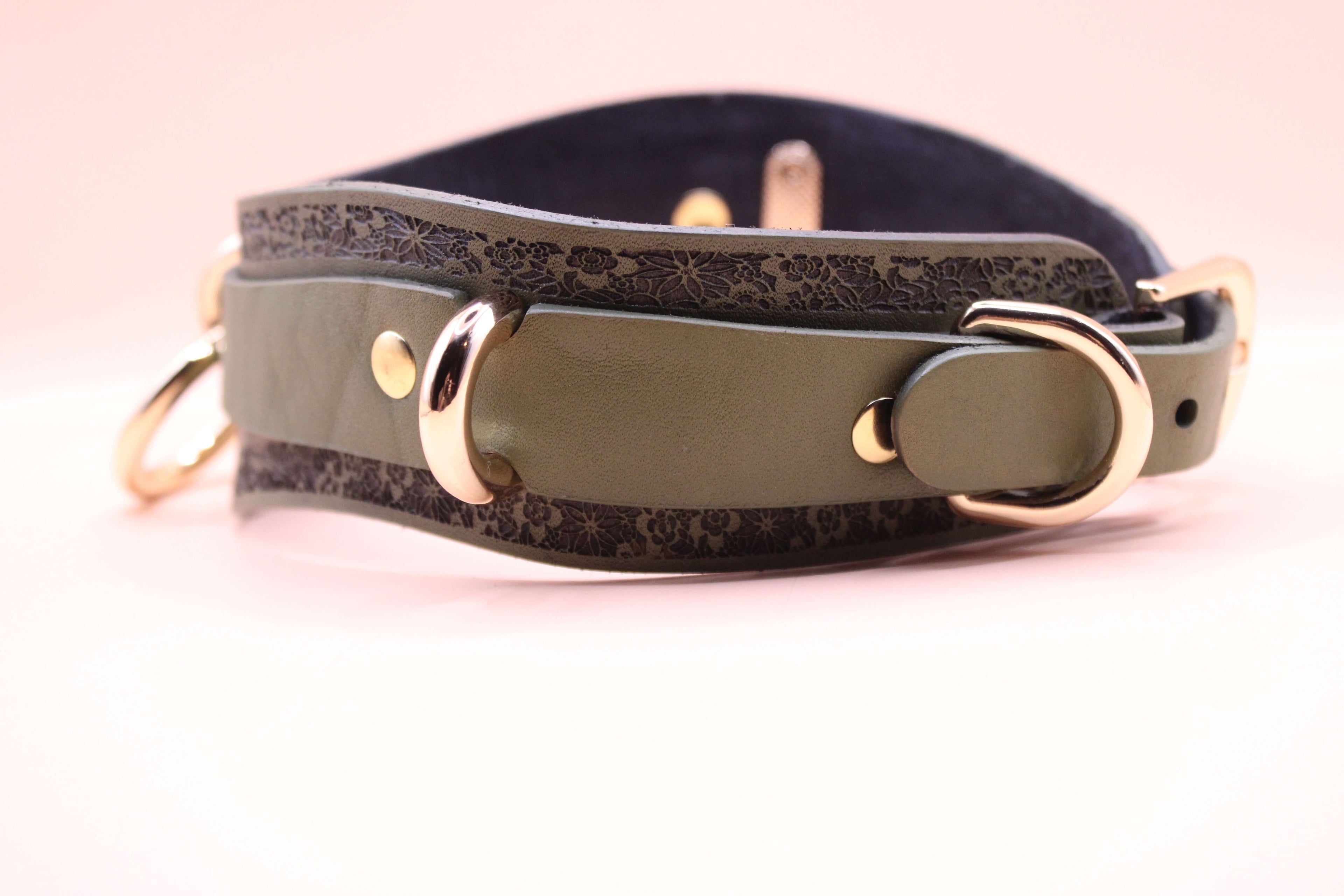 Avocado green leather choker with floral design, featuring gold hardware and a stylish, elegant look.