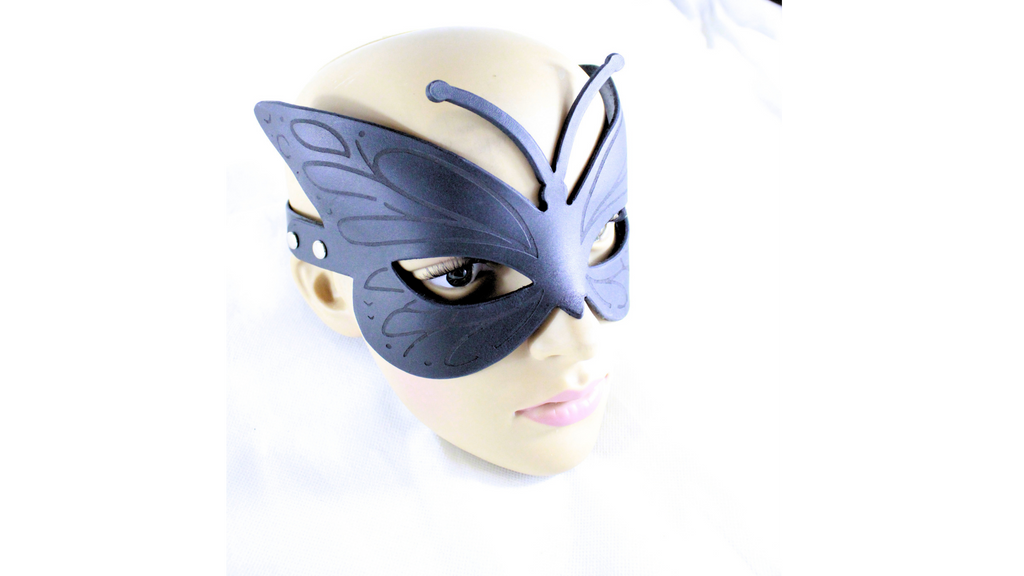A mannequin head wearing a black butterfly-shaped mask.