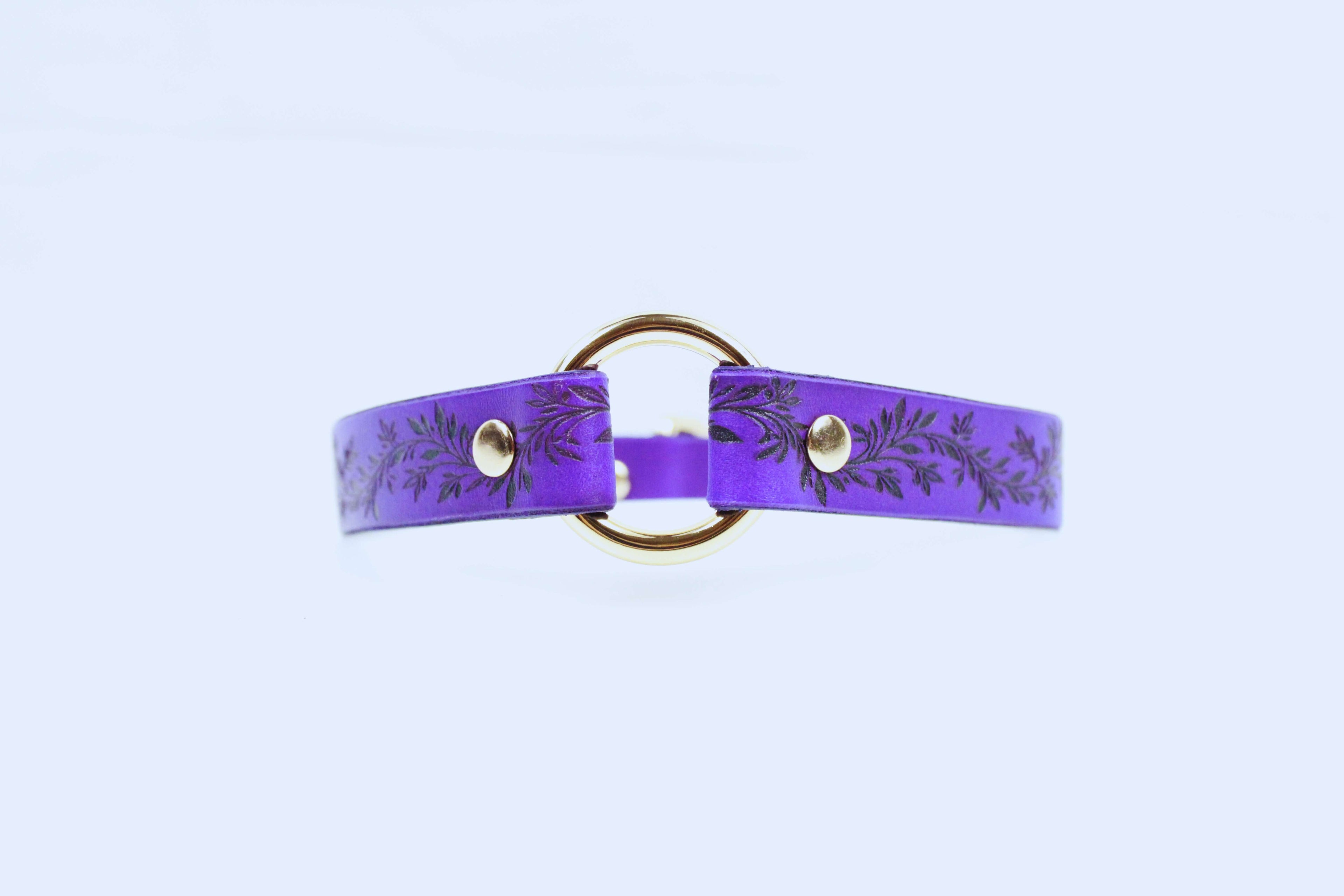 Leaf Pattern Submissive Day Collar in purple leather with a gold ring and floral design.