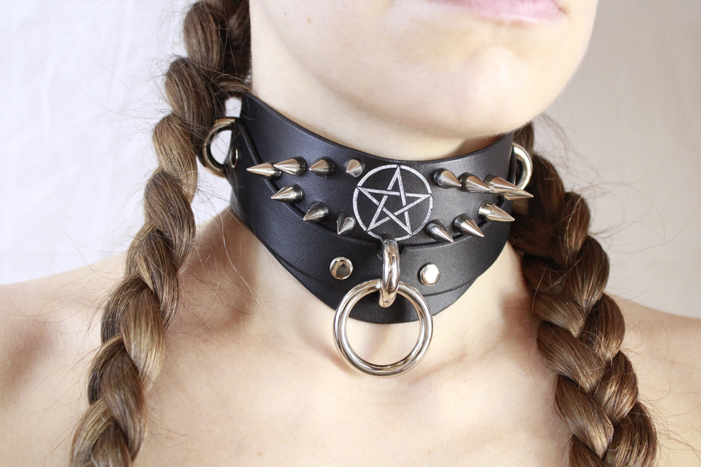Close-up of a woman wearing a Pentagram BDSM Collar with spikes and a central ring.