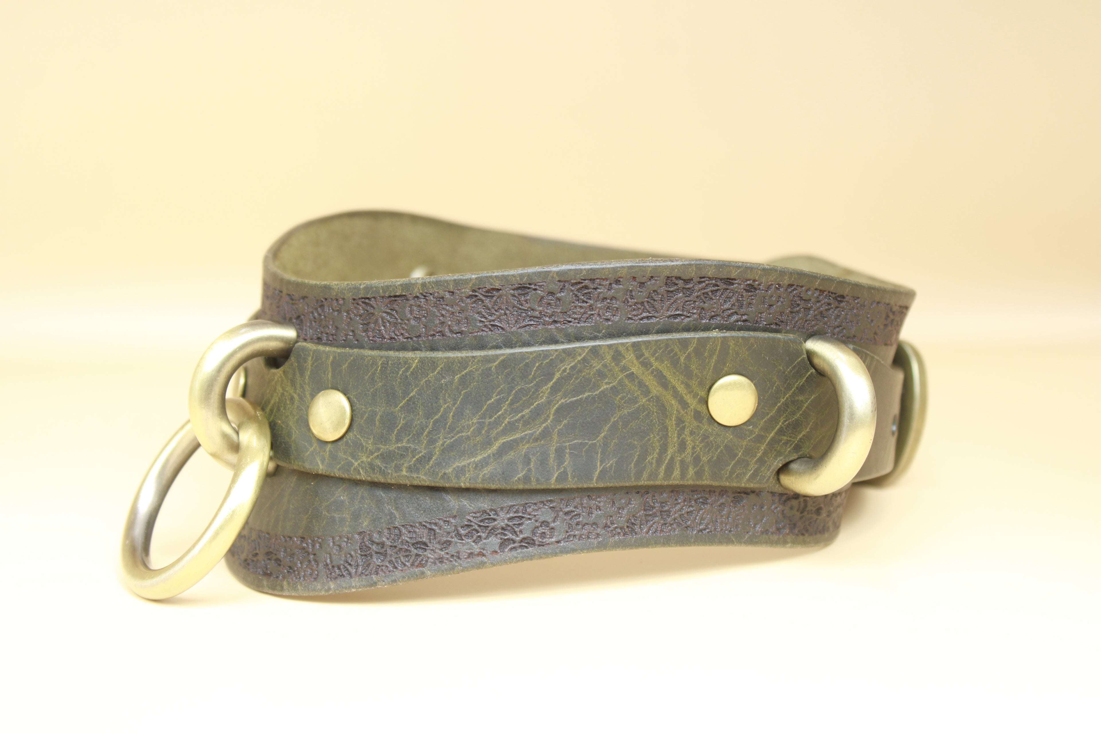 A leather strap with metal rings and buckles, likely used for securing or fastening items.