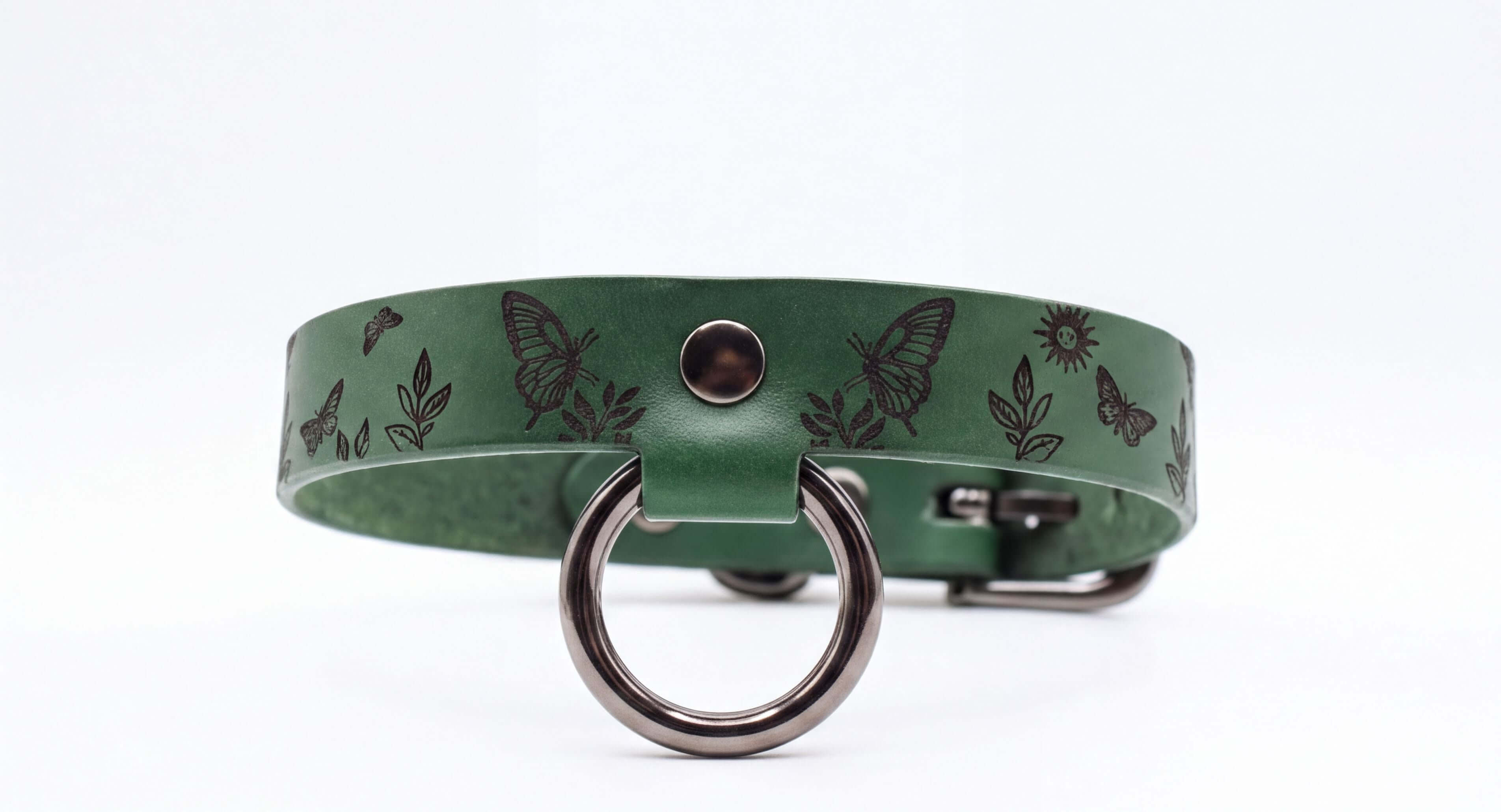 A green leather collar with a metal ring and butterflies printed on it.