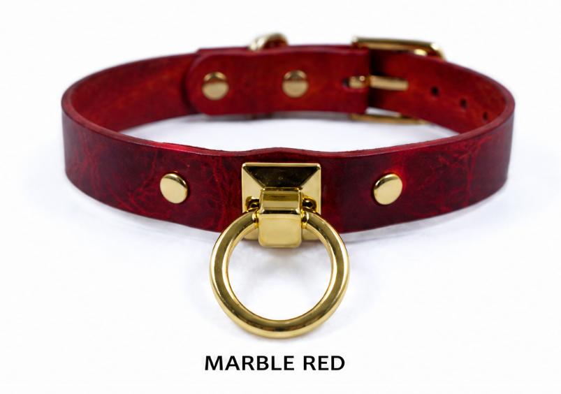 A red leather choker collar with a gold metal ring and buckle.