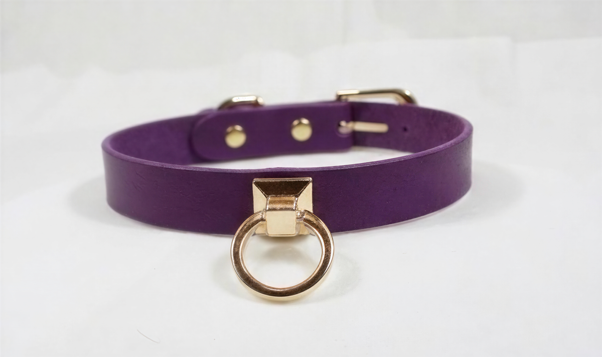 A purple leather choker necklace with a gold-colored metal ring and buckle.