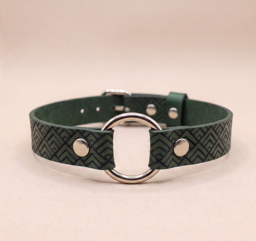 A green leather choker collar with a metal ring and two metal buttons.