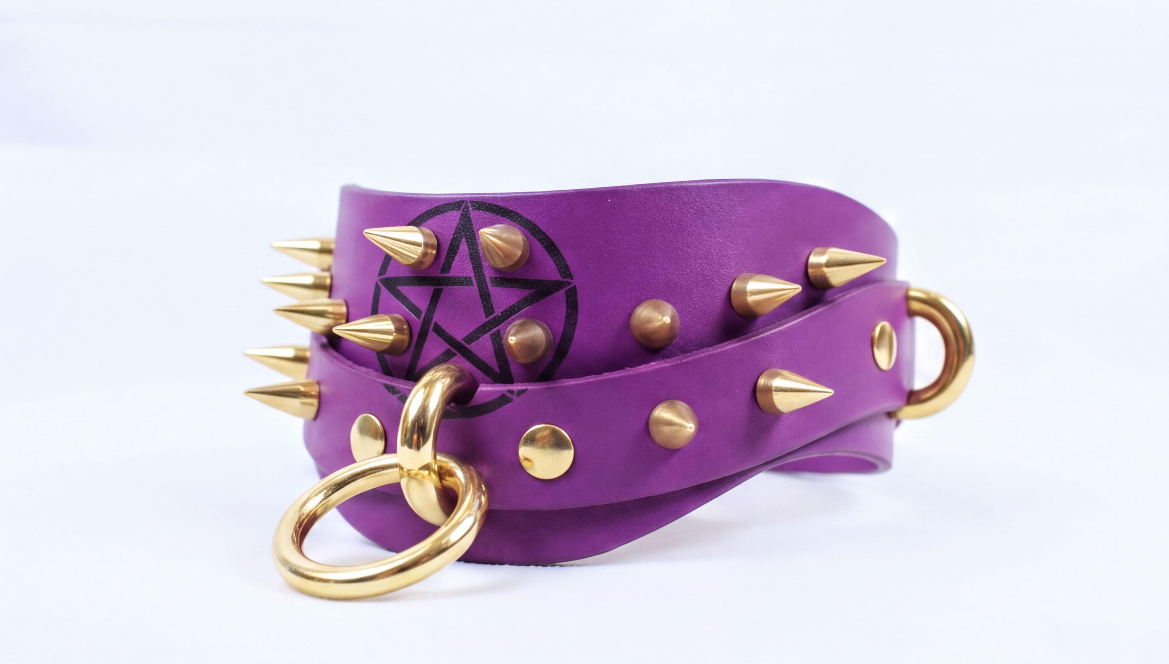 A purple leather choker necklace with gold spikes and a star-shaped emblem on the front.