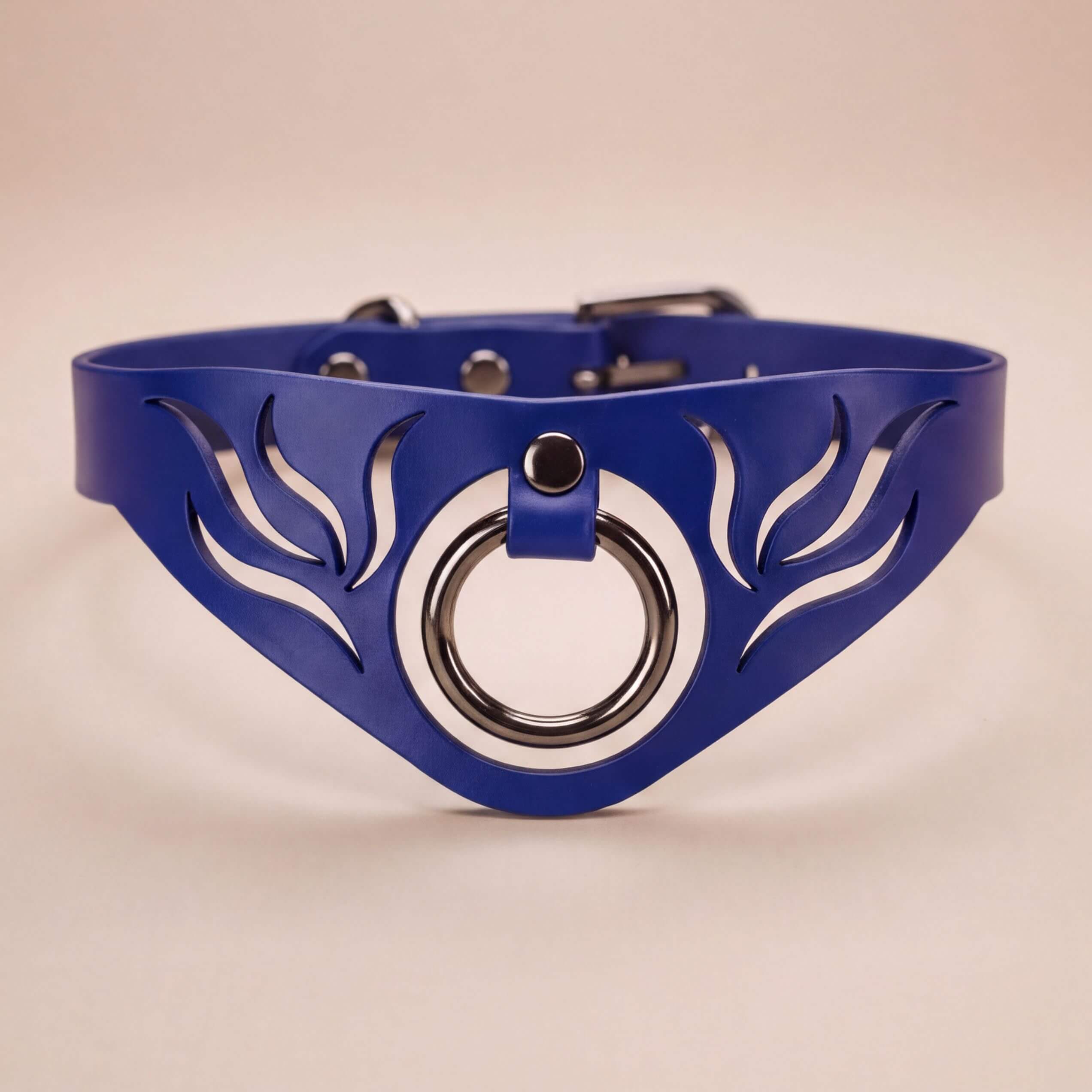 A blue leather choker necklace with a circular metal ring and a decorative leaf-like design on the front.
