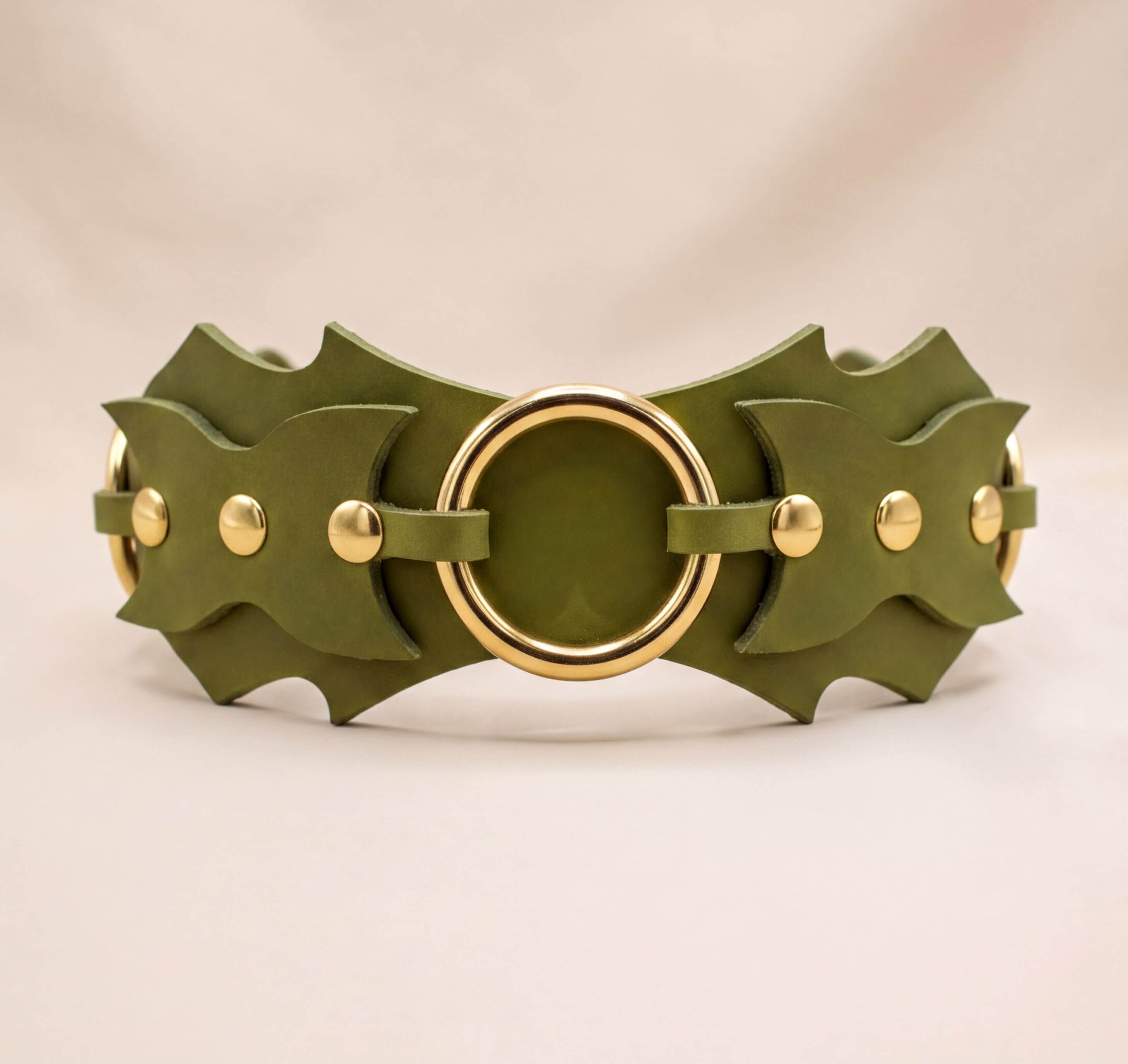 A green leather belt with gold-colored metal studs and a circular buckle.