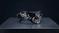 A black leather choker necklace with silver leaf-like designs and metal rings is displayed on a dark surface.