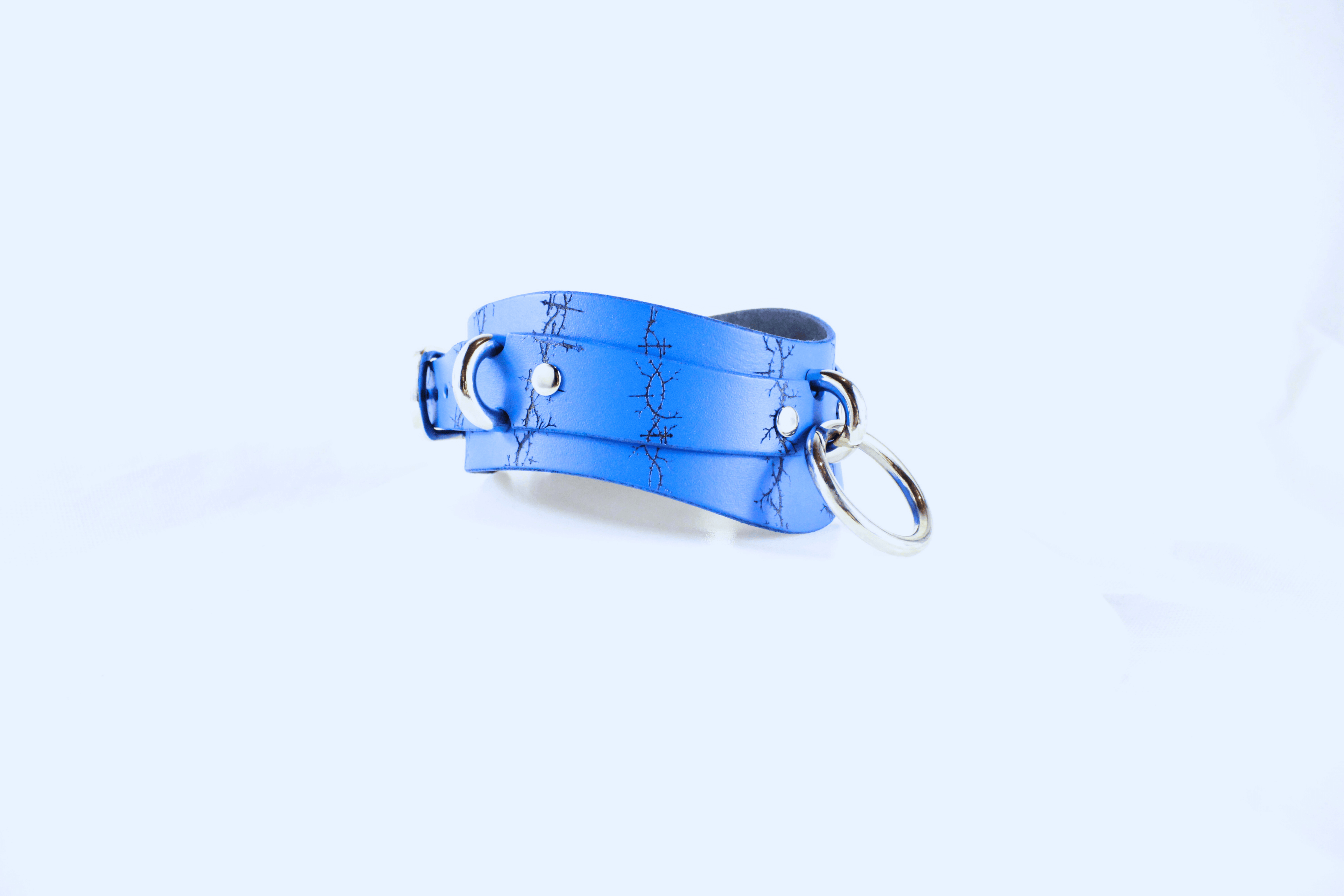 Barbed BDSM Collar in blue leather with rings and etched barbed design, showcasing raw elegance and craftsmanship.