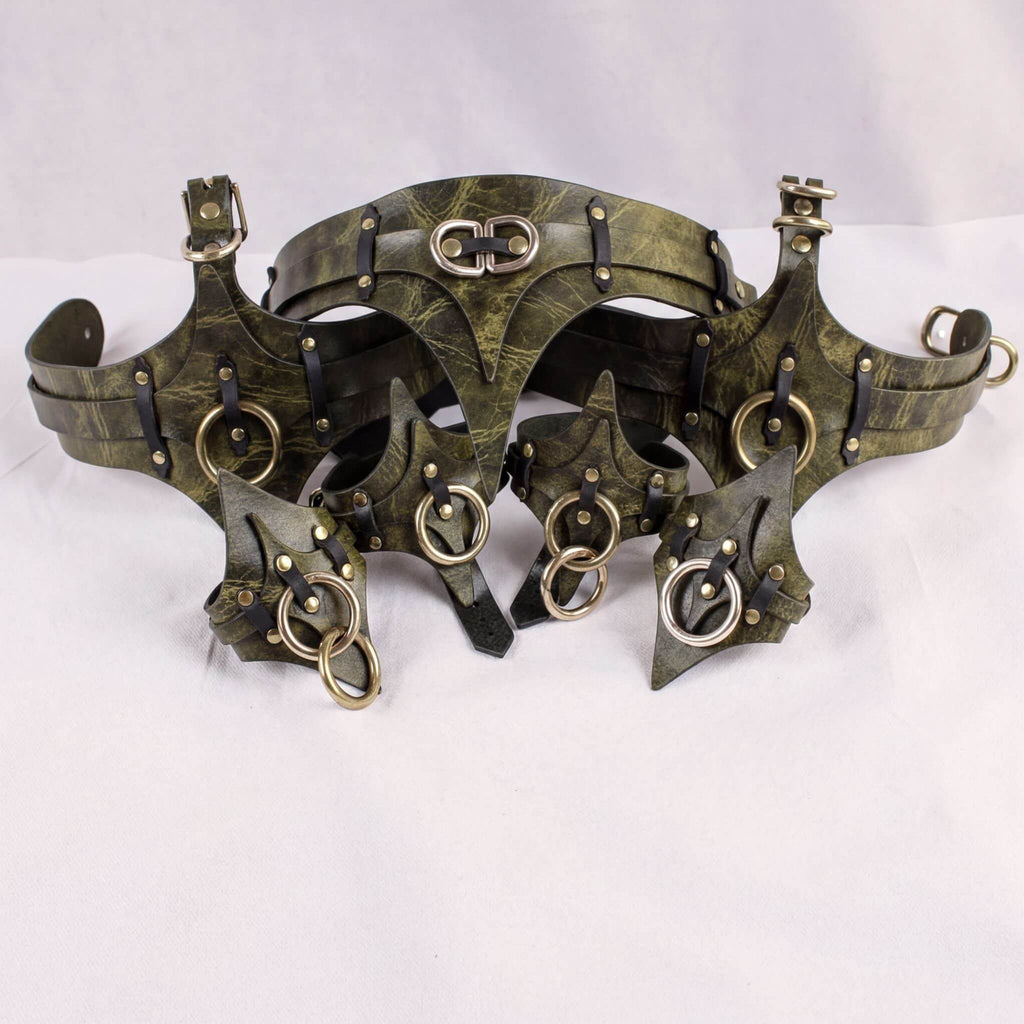 A pair of ornate leather straps with metal rings and buckles, likely used for decorative or functional purposes.