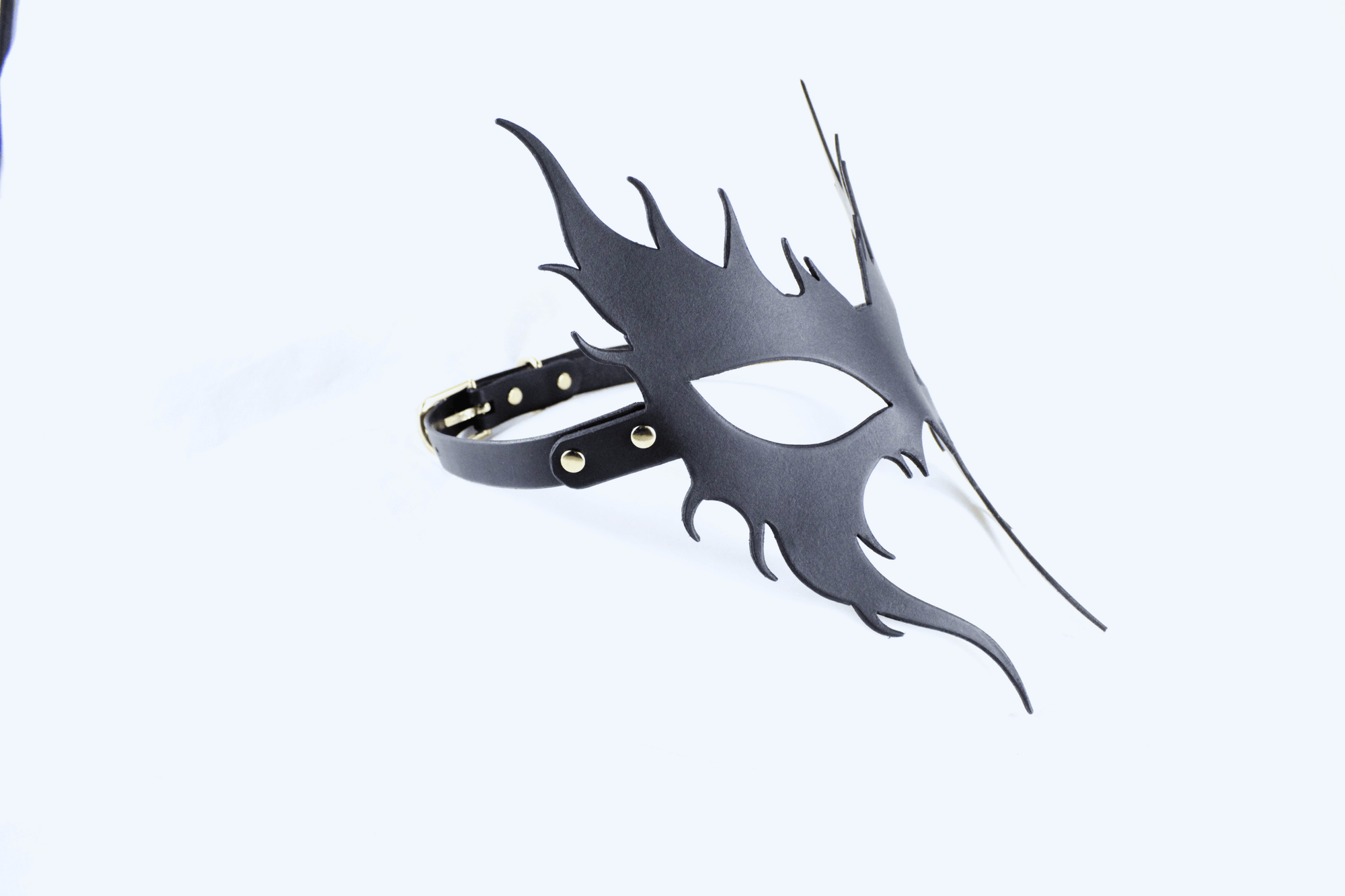 A black mask with a unique, stylized design is shown against a white background.