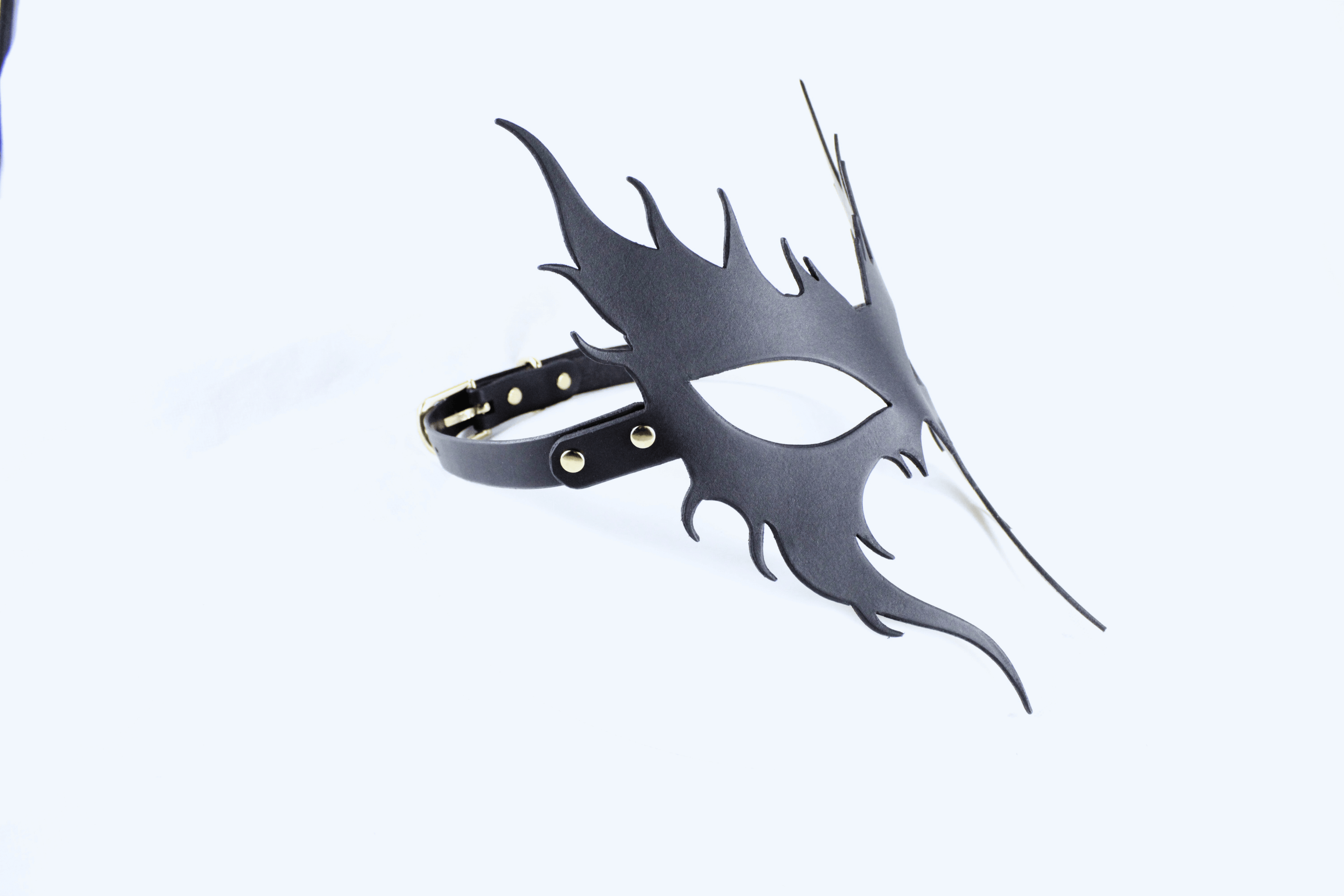 A black mask with a unique, stylized design is shown against a white background.