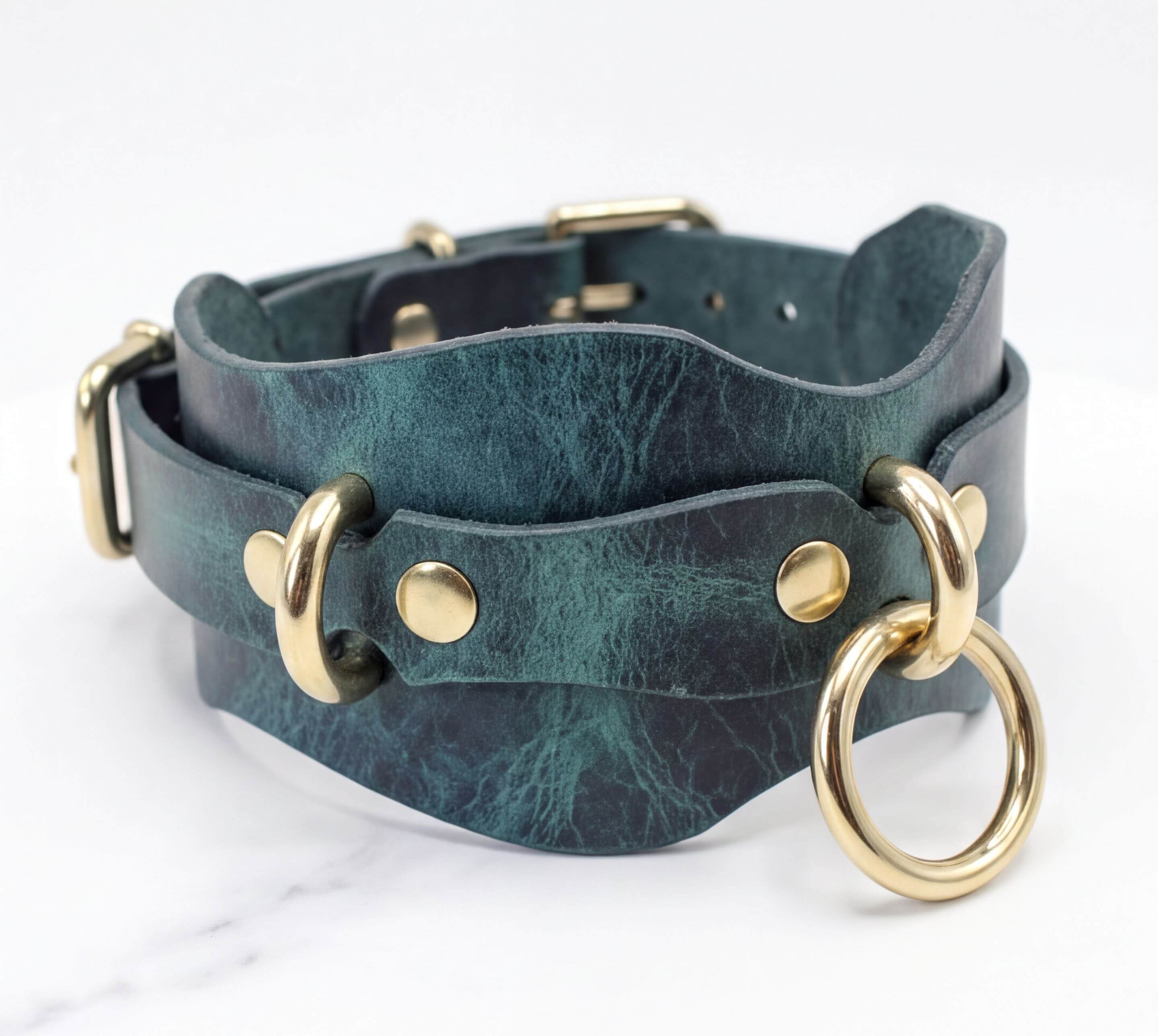 A dark green leather choker necklace with gold metal rings and buckles.