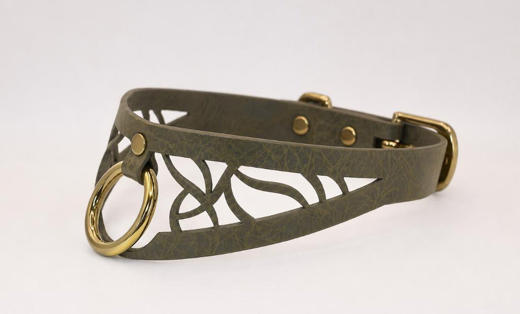 A dark green leather choker necklace with a gold-colored metal ring and a decorative cutout design.
