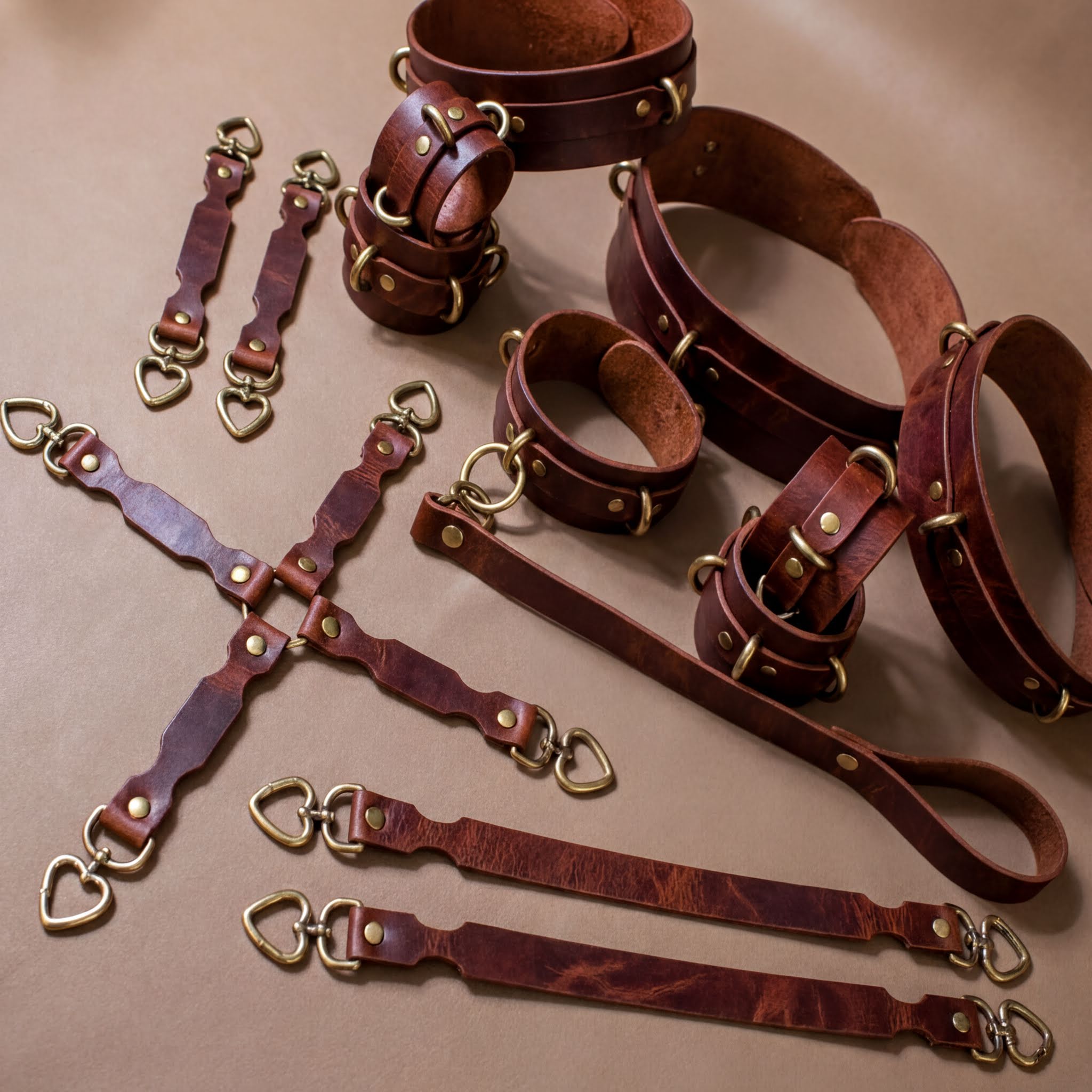 a collection of leather straps and buckles, likely used for securing or fastening items. The straps appear to be made of a dark brown leather material and are arranged in various positions, some overlapping each other. The image does not contain any text or specific details about the objects, and it does not provide any information about the context or purpose of the straps.