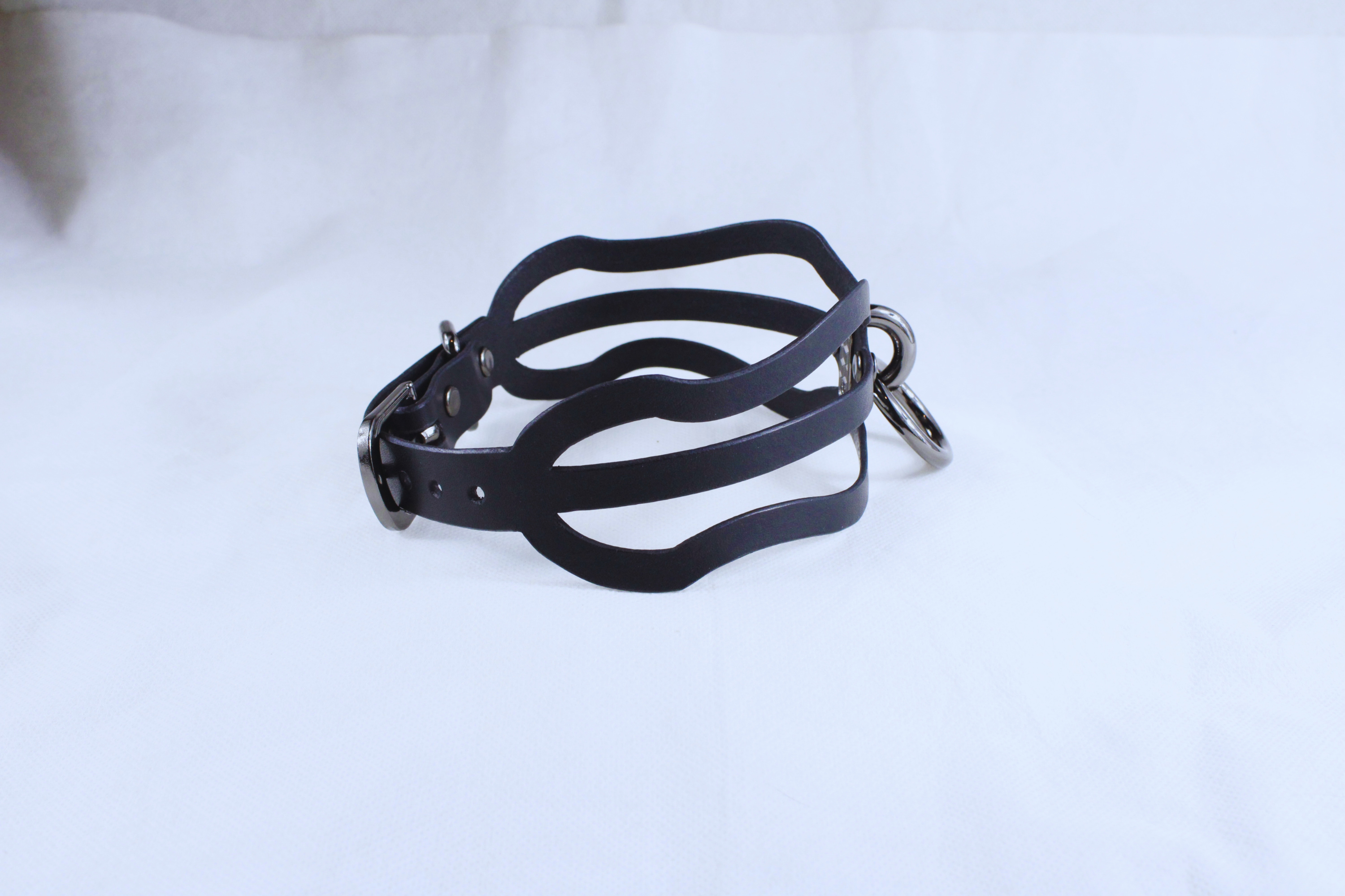 A black leather choker necklace with a metal clasp and buckle.