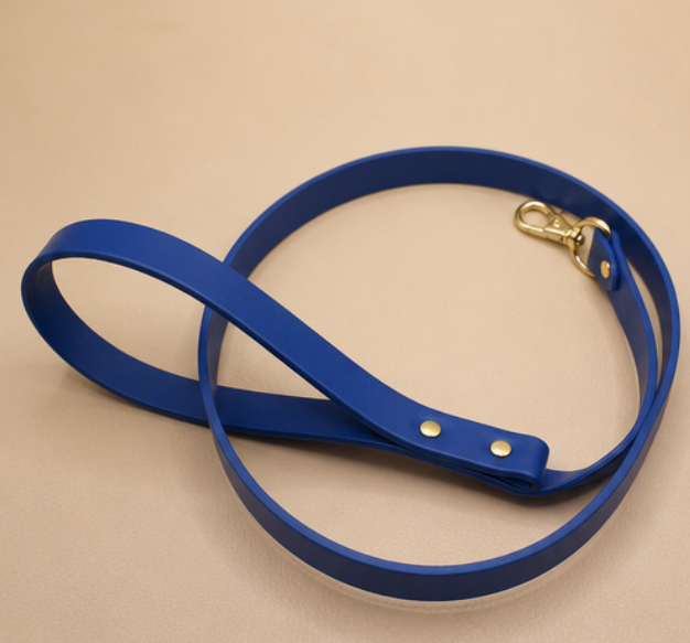 A blue leash with a gold buckle is shown on a beige surface.