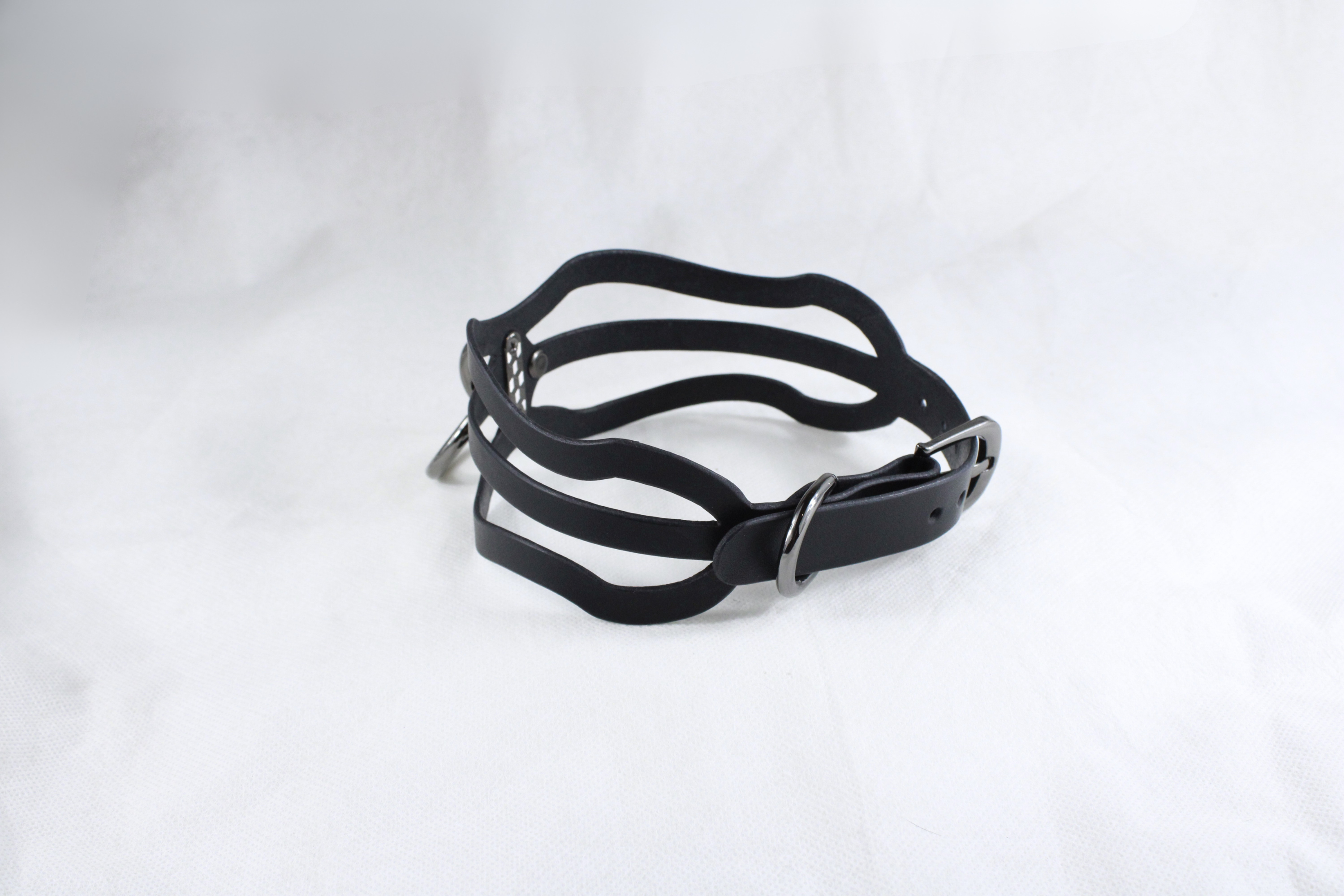 A black leather choker necklace with a unique, wavy design.