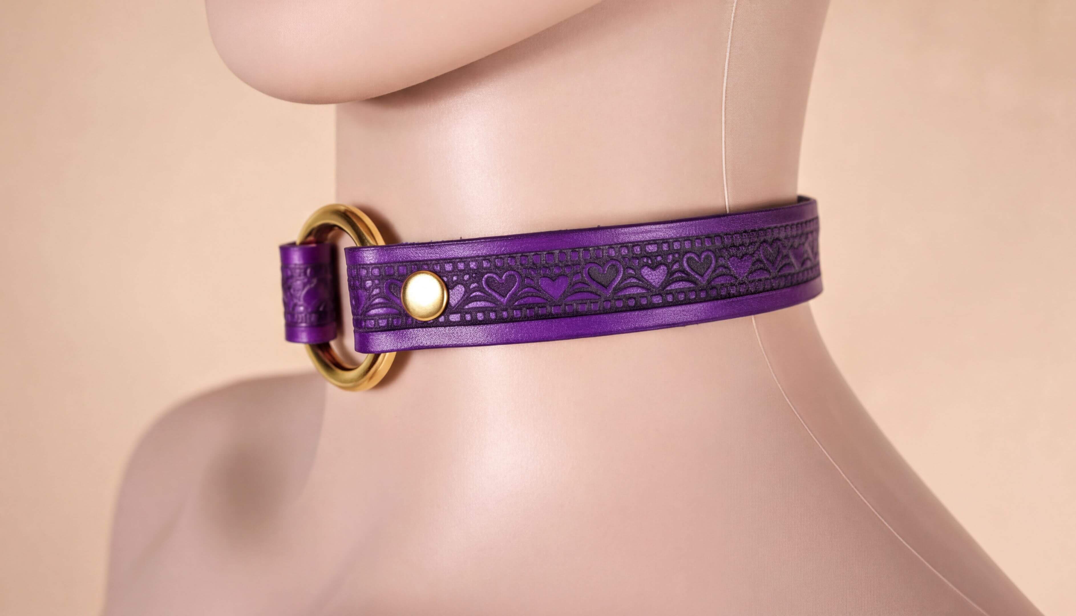 A mannequin head wearing a purple choker necklace with a gold-colored buckle.
