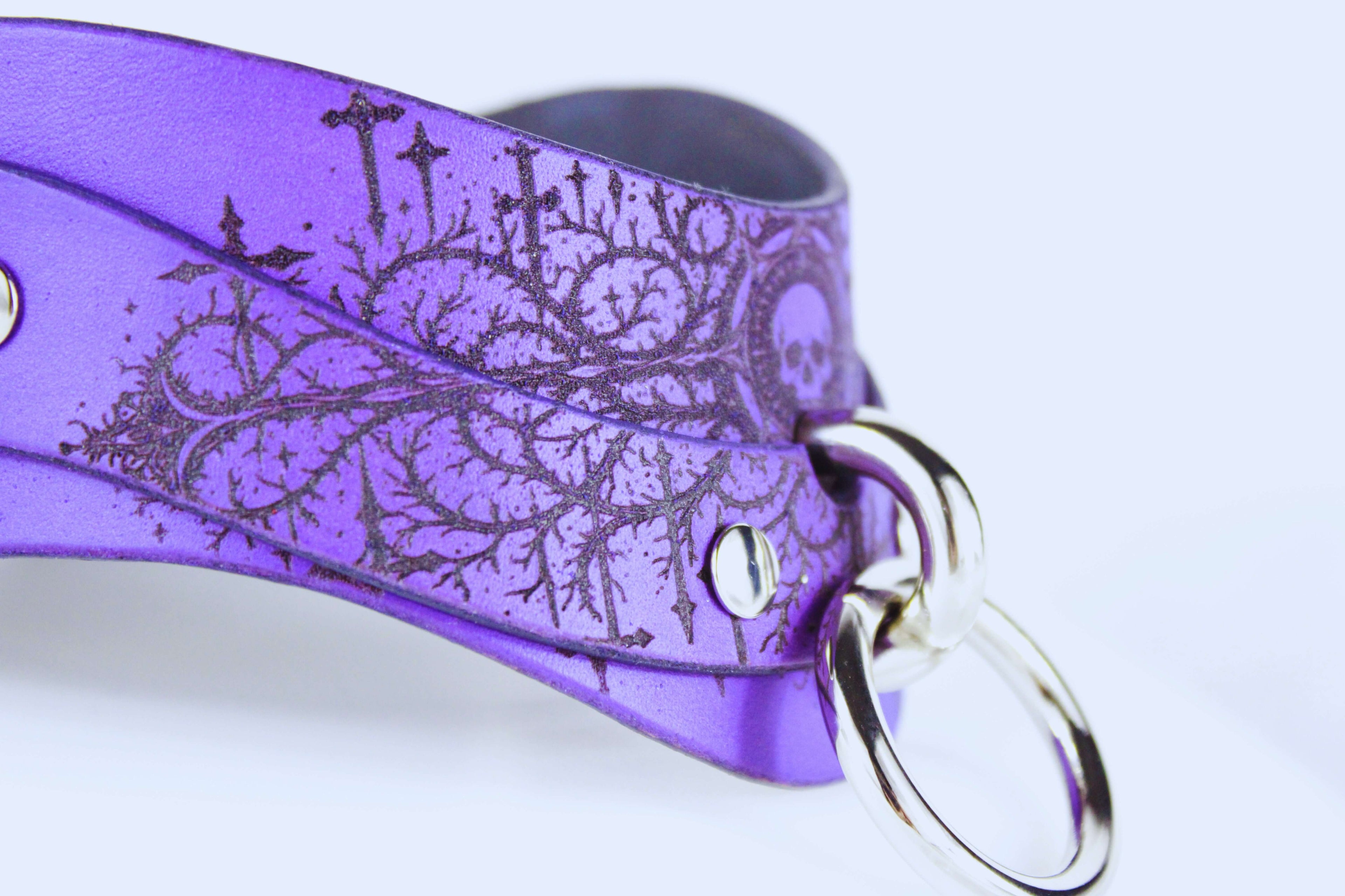 Gothic Skull BDSM Collar showing intricate design and O-ring on rich purple leather.