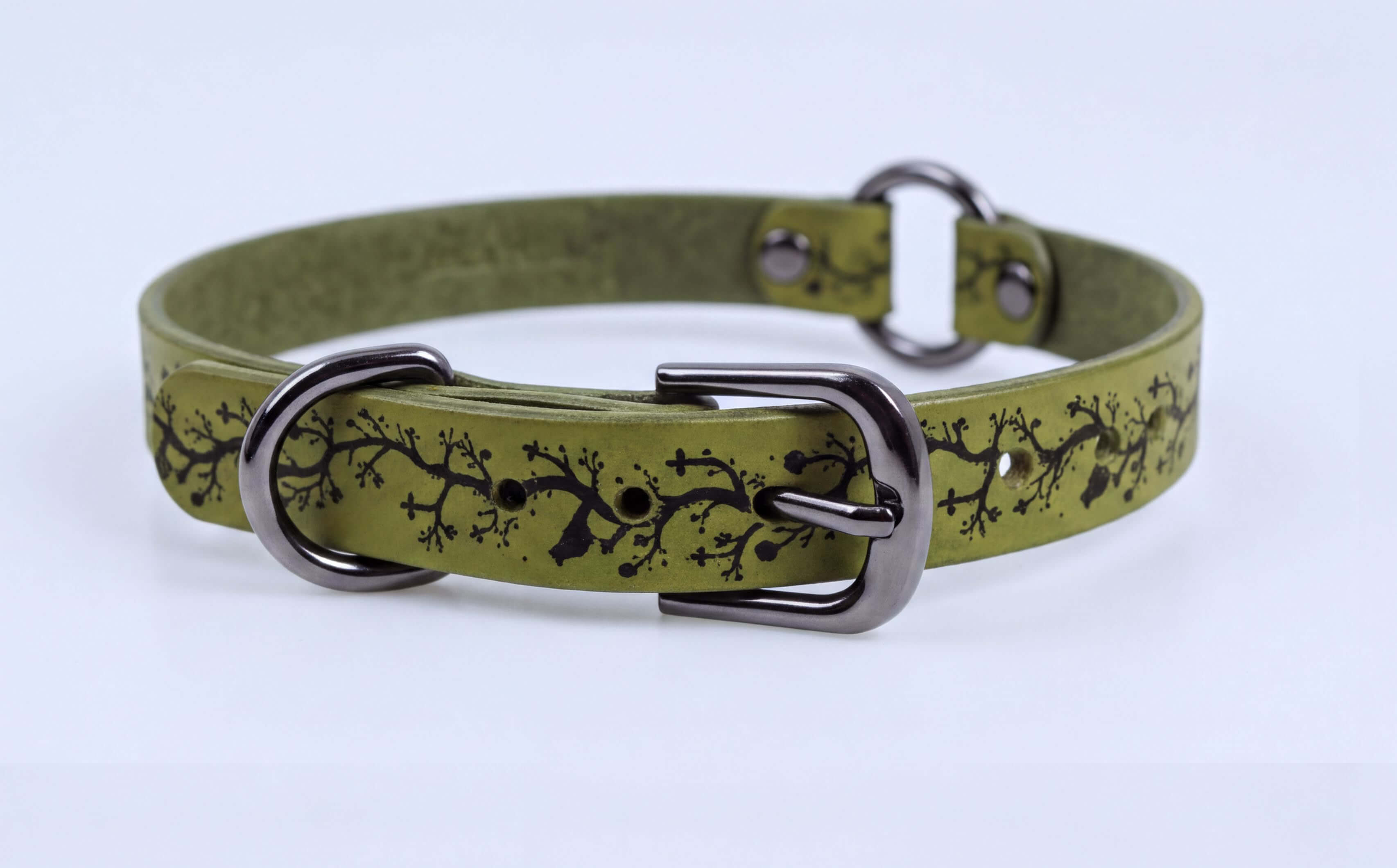 A green leather dog collar with a black tree branch design on it.